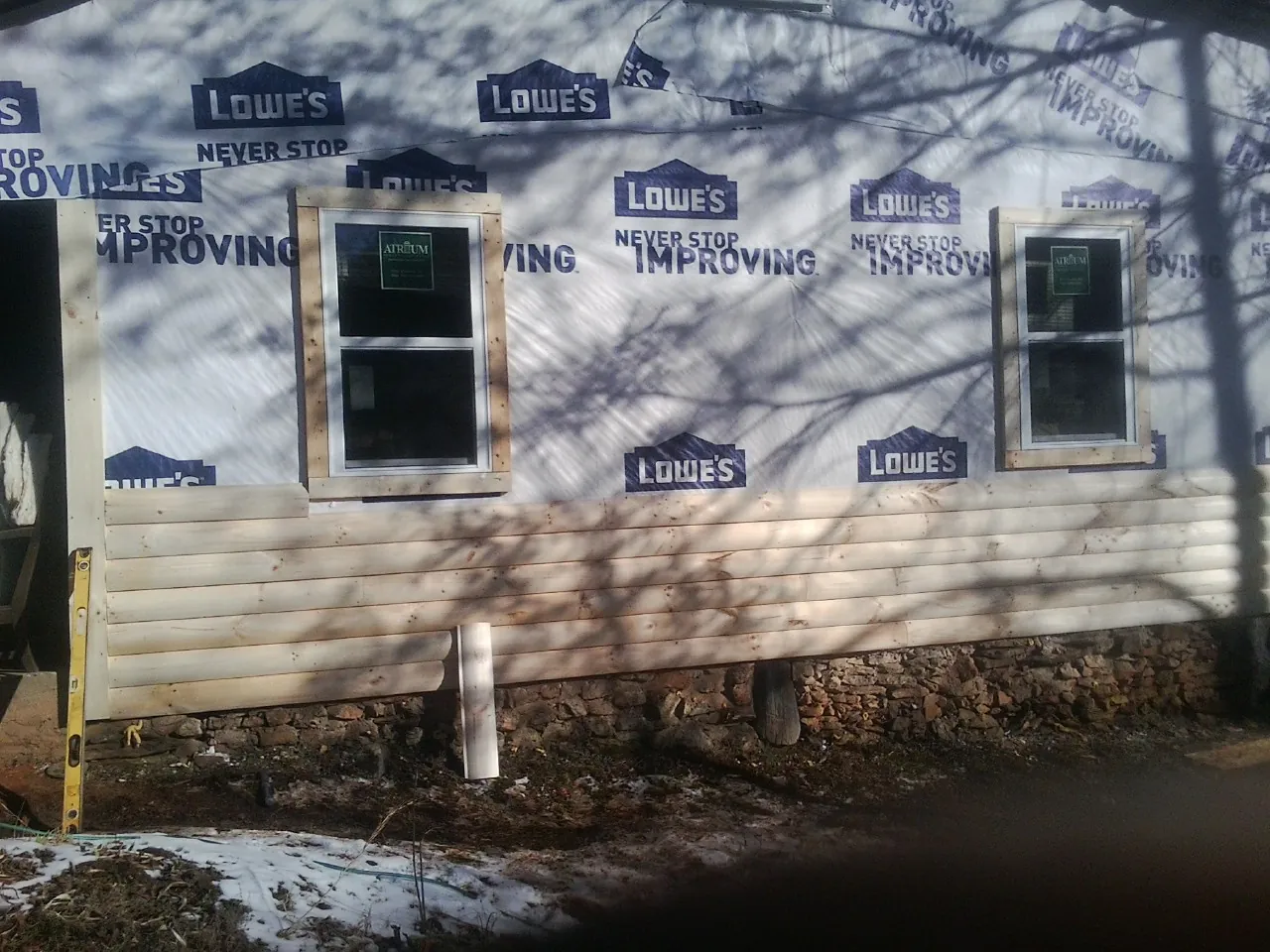House wrap and new log siding going up on an exterior wall in North Chili