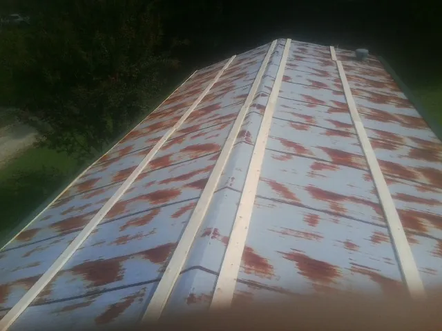 Rusted metal roof panels with new wood purlins before replacement — Storm Damage Roof Repair in North Chili by Roofing Brothers